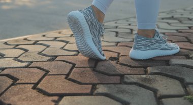 Genç sporcu kadın koşucu şehre koşmadan önce bacaklarını açıyor.