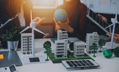 İş adamlarının şirket ofisinde rüzgar enerjisi hakkında görüşleri var. İş ekibi yel değirmeni ve alternatif yeşil enerji hakkında konuşuyor. Modern ofiste yönetici toplantısı.