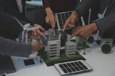 İş adamlarının şirket ofisinde rüzgar enerjisi hakkında görüşleri var. İş ekibi yel değirmeni ve alternatif yeşil enerji hakkında konuşuyor. Modern ofiste yönetici toplantısı.