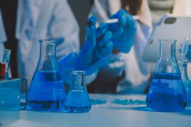 Kimyager ve bilim adamı test tüpüne kimyasal sıvı bırakıyor. Bilim araştırma ve geliştirme konsepti.