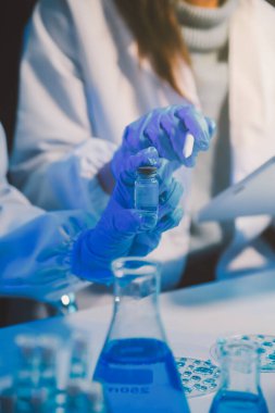 Kimyager ve bilim adamı test tüpüne kimyasal sıvı bırakıyor. Bilim araştırma ve geliştirme konsepti.