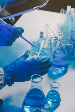 Kimyager ve bilim adamı test tüpüne kimyasal sıvı bırakıyor. Bilim araştırma ve geliştirme konsepti.