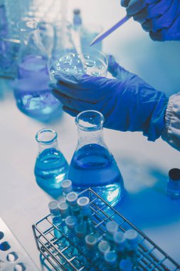 Kimyager ve bilim adamı test tüpüne kimyasal sıvı bırakıyor. Bilim araştırma ve geliştirme konsepti.