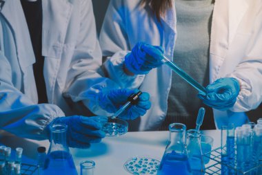 Kimyager ve bilim adamı test tüpüne kimyasal sıvı bırakıyor. Bilim araştırma ve geliştirme konsepti.