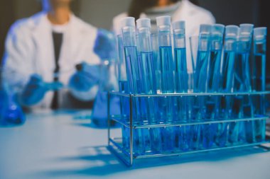 Kimyager ve bilim adamı test tüpüne kimyasal sıvı bırakıyor. Bilim araştırma ve geliştirme konsepti.