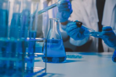 Kimyager ve bilim adamı test tüpüne kimyasal sıvı bırakıyor. Bilim araştırma ve geliştirme konsepti.