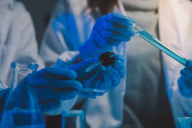 Kimyager ve bilim adamı test tüpüne kimyasal sıvı bırakıyor. Bilim araştırma ve geliştirme konsepti.