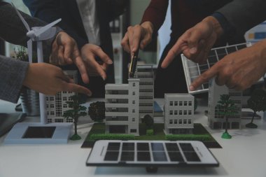 İş adamlarının şirket ofisinde rüzgar enerjisi hakkında görüşleri var. İş ekibi yel değirmeni ve alternatif yeşil enerji hakkında konuşuyor. Modern ofiste yönetici toplantısı.