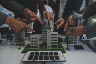 İş adamlarının şirket ofisinde rüzgar enerjisi hakkında görüşleri var. İş ekibi yel değirmeni ve alternatif yeşil enerji hakkında konuşuyor. Modern ofiste yönetici toplantısı.