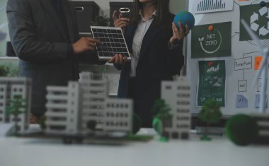 İş adamlarının şirket ofisinde rüzgar enerjisi hakkında görüşleri var. İş ekibi yel değirmeni ve alternatif yeşil enerji hakkında konuşuyor. Modern ofiste yönetici toplantısı.