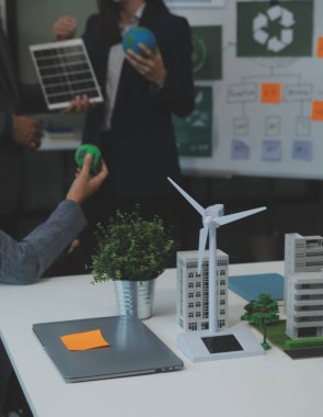 İş adamlarının şirket ofisinde rüzgar enerjisi hakkında görüşleri var. İş ekibi yel değirmeni ve alternatif yeşil enerji hakkında konuşuyor. Modern ofiste yönetici toplantısı.