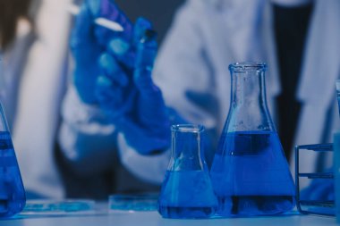 Kimyager ve bilim adamı test tüpüne kimyasal sıvı bırakıyor. Bilim araştırma ve geliştirme konsepti.