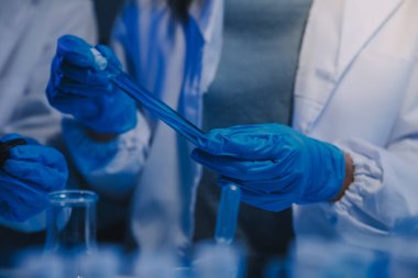 Kimyager ve bilim adamı test tüpüne kimyasal sıvı bırakıyor. Bilim araştırma ve geliştirme konsepti.