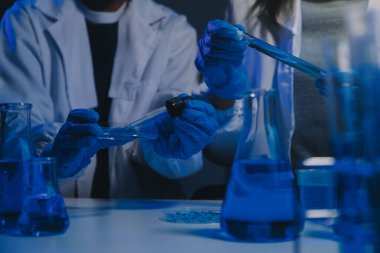 Kimyager ve bilim adamı test tüpüne kimyasal sıvı bırakıyor. Bilim araştırma ve geliştirme konsepti.