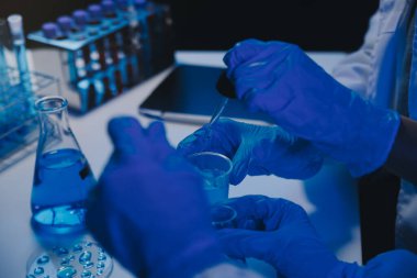 Kimyager ve bilim adamı test tüpüne kimyasal sıvı bırakıyor. Bilim araştırma ve geliştirme konsepti.