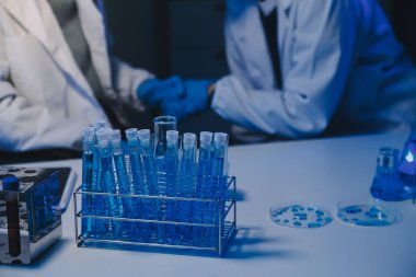 Kimyager ve bilim adamı test tüpüne kimyasal sıvı bırakıyor. Bilim araştırma ve geliştirme konsepti.