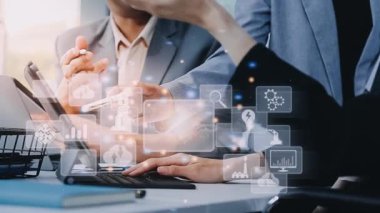 İş adamı, modern ofis masasında bilgisayar ve dijital arayüz simgeleriyle iş ve teknoloji konsepti için akıllı telefon kullanıyor