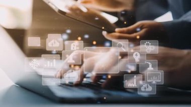 Dijital teknoloji simgeleriyle dizüstü bilgisayarda yazan iş adamı