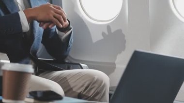 İş adamı havaalanında otururken dizüstü bilgisayar kullanıyor