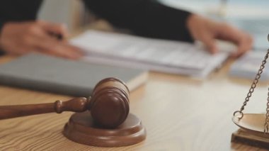 Avukat, ahşap masada dizüstü bilgisayar, tokmak ve adalet terazisiyle yeni iş sözleşmesi üzerinde çalışıyor.