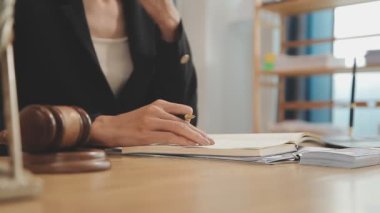 Avukat, ahşap masada dizüstü bilgisayar, tokmak ve adalet terazisiyle yeni iş sözleşmesi üzerinde çalışıyor.