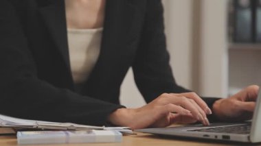 Avukat, ahşap masada dizüstü bilgisayar, tokmak ve adalet terazisiyle yeni iş sözleşmesi üzerinde çalışıyor.