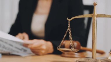 Avukat, ahşap masada dizüstü bilgisayar, tokmak ve adalet terazisiyle yeni iş sözleşmesi üzerinde çalışıyor.