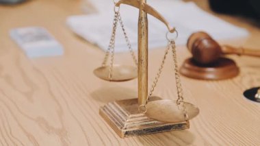 Avukat, ahşap masada dizüstü bilgisayar, tokmak ve adalet terazisiyle yeni iş sözleşmesi üzerinde çalışıyor.