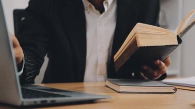 Adam kütüphanede kitap okuyor.