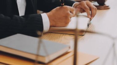 Yargıç tokmağı ve avukatı masada çalışıyor.