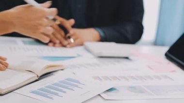 Modern ofiste finansal tablolar üzerinde çalışan iş adamları.