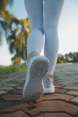 Genç sporcu kadın koşucu şehre koşmadan önce bacaklarını açıyor.