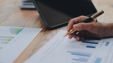 Modern ofiste belgelerle çalışan genç bir iş kadını.