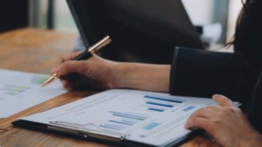 Modern ofiste belgelerle çalışan genç bir iş kadını.