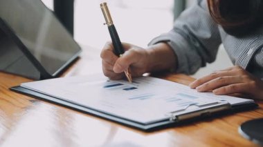 Belgeler ve grafikler üzerinde çalışırken iş kadınının tablet kullandığı yakın plan görüntüsü 