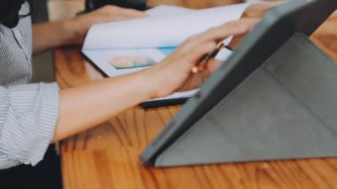 Belgeler ve grafikler üzerinde çalışırken iş kadınının tablet kullandığı yakın plan görüntüsü 