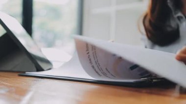 Belgeler ve grafikler üzerinde çalışırken iş kadınının tablet kullandığı yakın plan görüntüsü 