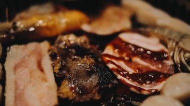 Geleneksel Yakiniku yemek stillerini kullanarak et ve karides ızgarası yapan insanların yakın çekim görüntüsü