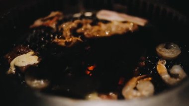 Sığır eti ve deniz ürünleri ızgarası yapan insanların yakınındaki manzara. Japonya 'da birçok insan Yakiniku denilen bu yemek yapma tarzını sever.