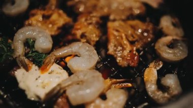 Sığır eti ve deniz ürünleri ızgarası yapan insanların yakınındaki manzara. Japonya 'da birçok insan Yakiniku denilen bu yemek yapma tarzını sever.