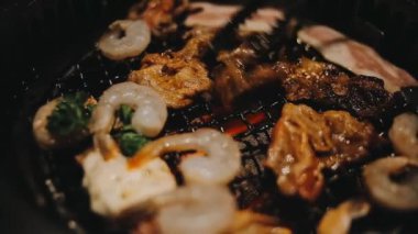 Sığır eti ve deniz ürünleri ızgarası yapan insanların yakınındaki manzara. Japonya 'da birçok insan Yakiniku denilen bu yemek yapma tarzını sever.