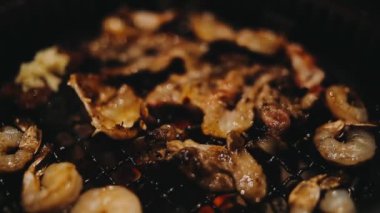 Sığır eti ve deniz ürünleri ızgarası yapan insanların yakınındaki manzara. Japonya 'da birçok insan Yakiniku denilen bu yemek yapma tarzını sever.