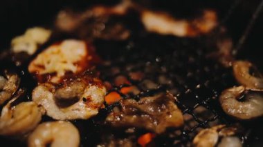 Sığır eti ve deniz ürünleri ızgarası yapan insanların yakınındaki manzara. Japonya 'da birçok insan Yakiniku denilen bu yemek yapma tarzını sever.