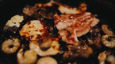 Sığır eti ve deniz ürünleri ızgarası yapan insanların yakınındaki manzara. Japonya 'da birçok insan Yakiniku denilen bu yemek yapma tarzını sever.