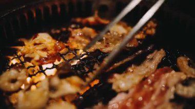 Sığır eti ve deniz ürünleri ızgarası yapan insanların yakınındaki manzara. Japonya 'da birçok insan Yakiniku denilen bu yemek yapma tarzını sever.