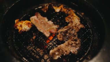 Izgarada et ve karides pişiren insanların yakın çekim görüntüsü. Yakiniku, Japonya 'da yemek yemenin çok popüler bir yoludur..
