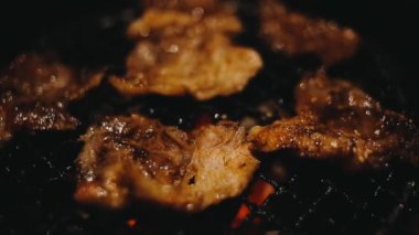 Izgarada et ve karides pişiren insanların yakın çekim görüntüsü. Yakiniku, Japonya 'da yemek yemenin çok popüler bir yoludur..