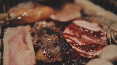 Izgarada et ve karides pişiren insanların yakın çekim görüntüsü. Yakiniku, Japonya 'da yemek yemenin çok popüler bir yoludur..