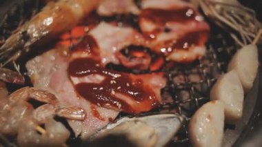 Masa başı ızgarasında deniz ürünleri ve sığır eti hazırlayan lokantaların detaylı görüntüleri. Yakiniku olarak bilinen bu Japon barbekü metodu, sevilen bir aşçılık geleneğidir..