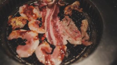 İnsanların ızgara et ve karides pişirmesini yakından izliyoruz. Yakiniku, Japonya 'nın en popüler yemek pişirme tarzlarından biridir..